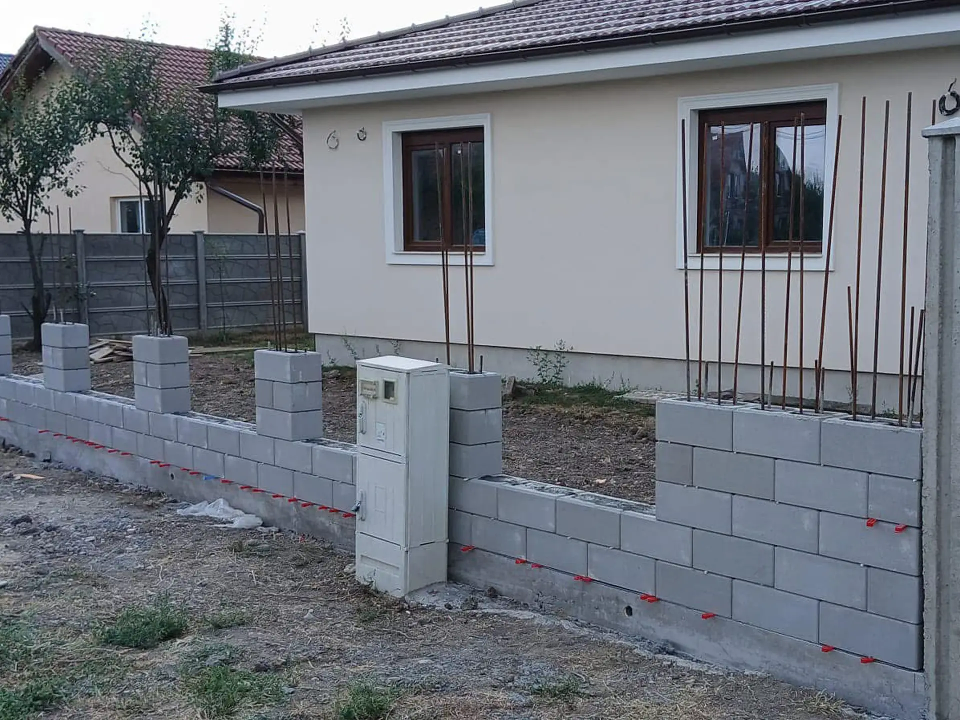 Szürke zsalukő kerítés falazása ipari telephelyen